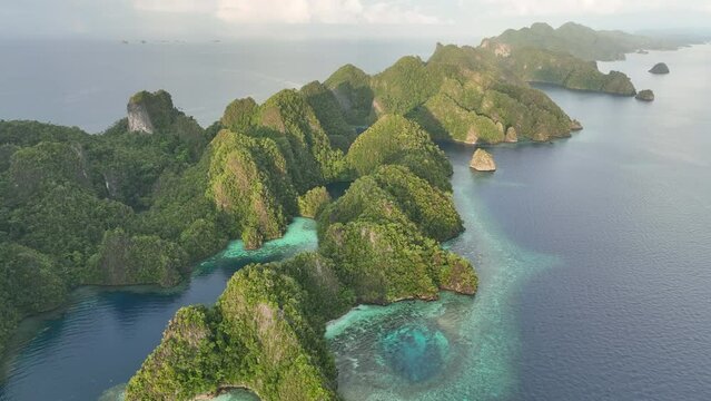 Early in the morning, calm seas surround the limestone islands that emerge from Raja Ampat's dramatic seascape. This remote part of Indonesia is known for its incredibly high marine biodiversity.