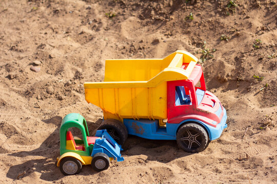Children's toy cars in the sandbox.Forgotten toys.