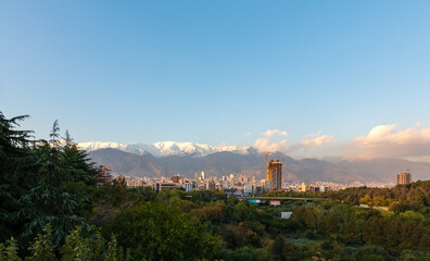 Skyline and cityscape of northern Tehran and Alborz mountain range viewed from the pedestrian Tabiat Bridge in Tehran, Iran.