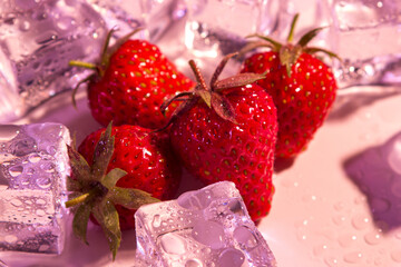 Strawberries with ice cubes under colored lighting. fresh red strawberry