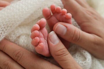 Obraz na płótnie Canvas Mother is doing massage on her baby foot. Closeup baby feet in mother hands. Prevention of flat feet, development, muscle tone, dysplasia. Family, love, care, and health concepts. Studio macro. 