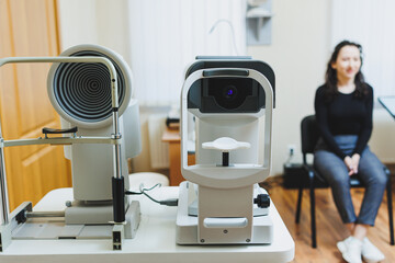 Examination of vision on modern ophthalmological equipment. Eye examination of a woman at an...
