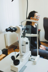 Examination of vision on modern ophthalmological equipment. Eye examination of a woman at an ophthalmologist's appointment using microscopes. Vision treatment at an ophthalmologist appointment