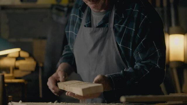 Hands, Owners of a medium-sized business In the process Blowing shavings from a tree In a craftsman's workshop Close-up Skilled worker Working at a carpenter's table In a craftsman's workshop handmade