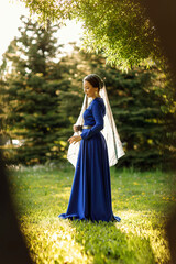 Obraz na płótnie Canvas a girl in a blue dress in a spring forest