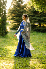 a girl in a blue dress in a spring forest