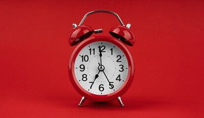 Red alarm clock on a red background.