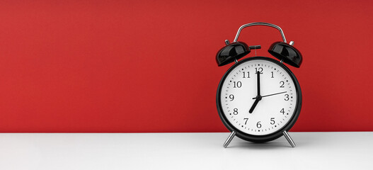 Black alarm clock on a red background