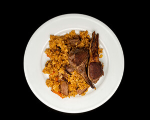 Homemade fried rice with grilled lamb on a white plate, isolated on black background. Top view or flat lay.