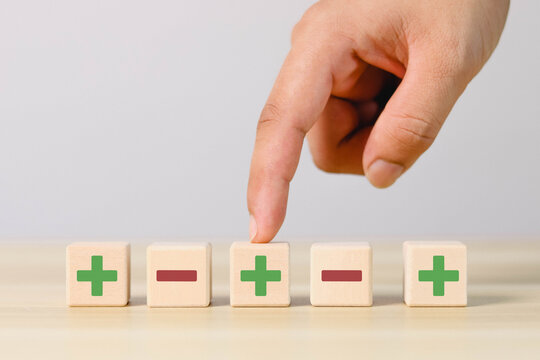 Wooden blocks showing plus and minus signs. The concept of antithesis. Decision making. Positive or negative business choice. Analysis of advantages and disadvantages Comparison	