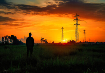 man in silhouette in the field, as dawn breaks