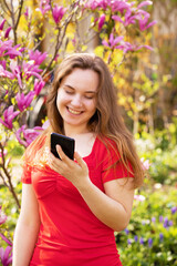 Happy young woman blogger influencer. Smiling vlogger girl looking at mobile make video call, shooting vlog taking selfie