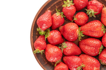 Several sweet strawberries with clay dish on white background, macro, top view.