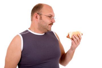 Overweight man looking at the hot dog in his hand
