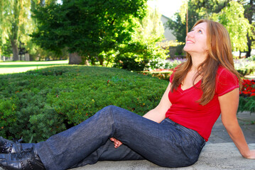 Obraz premium Mature woman relaxing outside in summer park