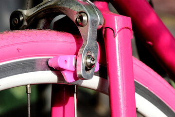 closeup of vintage style racing bicycle fork and front brake. pink rubber tire and brake pads....