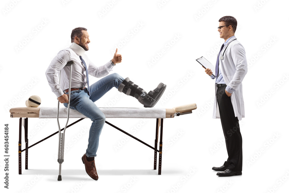 Sticker Injured man with an orthopedic boot and neck collar sitting on a therapy table and gesturing thumbs up in front of a doctor