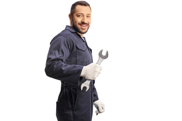 Car mechanic holding a wrench and looking over shoulder - obrazy, fototapety, plakaty