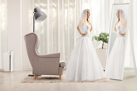 Profile shot of a bride standing in front of a mirror at home