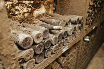 Dusty old wine bottles in the wine cellar of a winery 