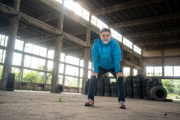 Fototapeta na wymiar Portrait of a smiling mature male athlete resting after run