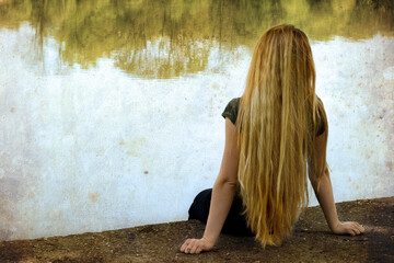 Solitude: blond woman standing alone on lakeside