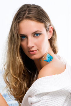 blond girl with blue eyes and a butterfly on her shoulder