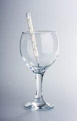 The thermometer in a glass glass on a white background
