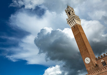 Torre del Mangia among spring clouds, Siena, Tuscany, Italy