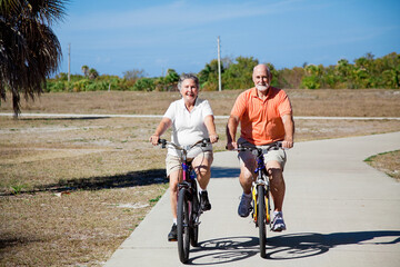 Happy active senior couple riding their bicycles.