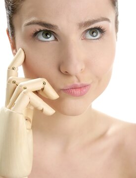 Funny woman cosmetic portrait, thinking with mannequin wooden hand