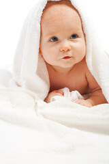 Curious baby lying under white towel, isolated
