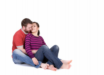 Fototapeta premium young happy couple sitting together on white background