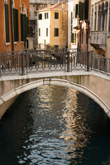 Obraz na płótnie Canvas Canal and walking bridge surrounded by Old World buildings in Venice, Italy. Vertical shot.