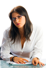 a young and cute brunette as secretary with glasses wearing a white shirt