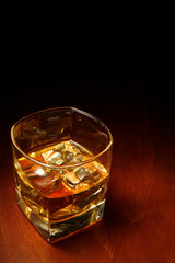 Whiskey in light pool on brown table with copyspace