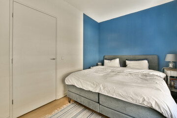 Fototapeta na wymiar a bedroom with blue walls and white furniture in the corner, including a bed that's made to look like a headboard