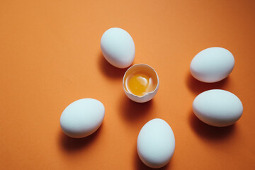 White eggs and egg yolk on the yellow background.