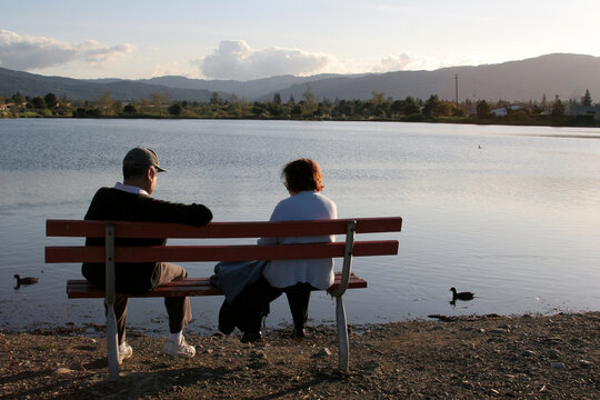 Older couple resting in the park, watching the ducks