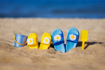 Obraz premium Childrens flip-flops on the beach. Summer vacation concept