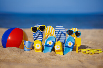 Family flip-flops, beach ball and snorkel on the sand. Summer vacation concept