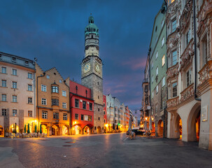 Innsbruck, Austria - view of historic Stadtturm tower with clock at dusk - obrazy, fototapety, plakaty