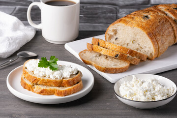 Sandwiches with cottage cheese and bread with olives on a gray table