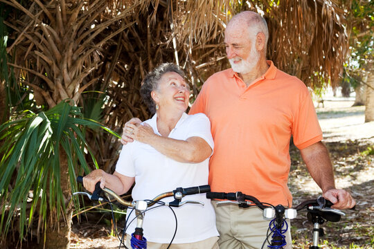 Senior couple bicycling together in the park.