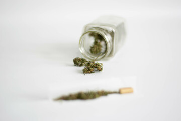 Fototapeta na wymiar Jar with marijuana flowers and rolled cigarette