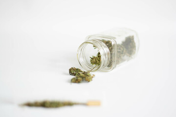 Jar with marijuana flowers and rolled cigarette