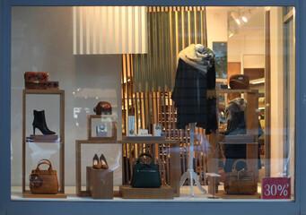 Shop window with shoes, bag and accessories. Evening light.