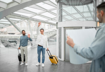 Guy Meeting His Travelers Friends Holding Paper Sign At Airport