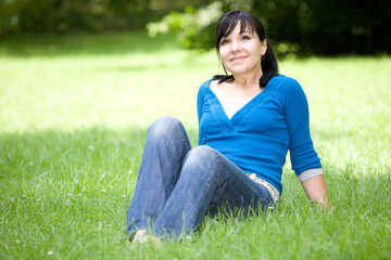 attractive woman relaxing on grass in park