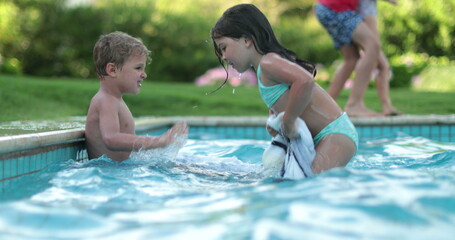Children fighting each other at swimming pool. Kids brother and sister quarrel